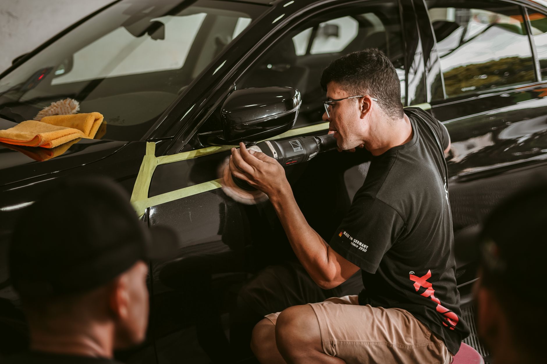 Mechanic closely polishing car door panel