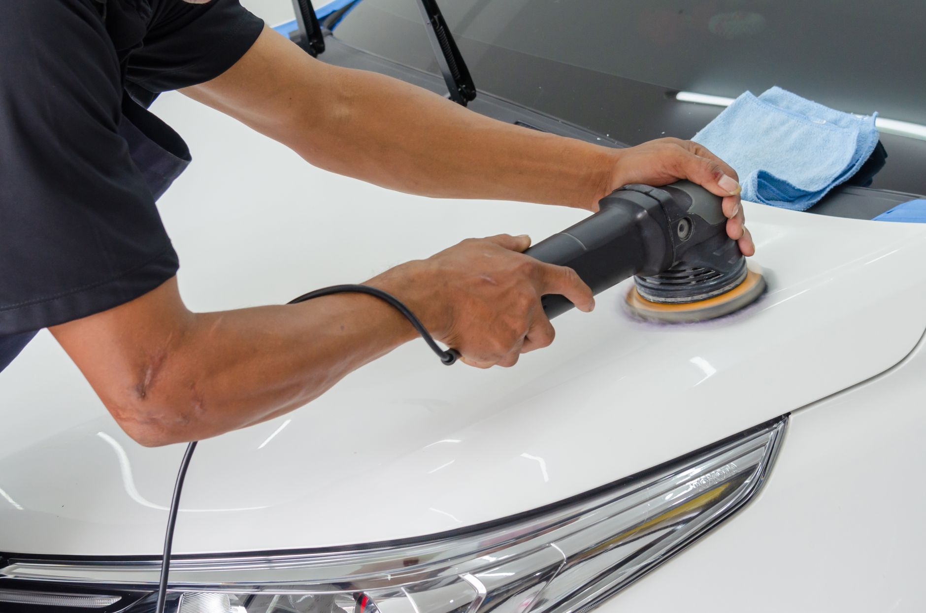 Close-up of car polishing with rotary buffer